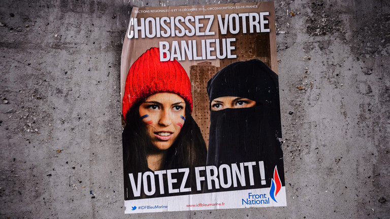Ein Wahlplakat der rechten französischen Partei Front National: Es zeigt eine Frau mit der Französischen Flagge und eine verschleierte Frau. Dazu der Satz: "Wähle dein Viertel. Wähle Front National."
