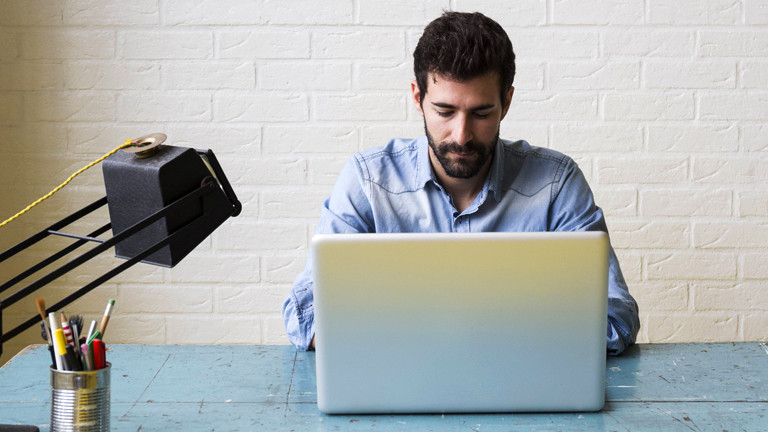 Mann an Laptop im Büro