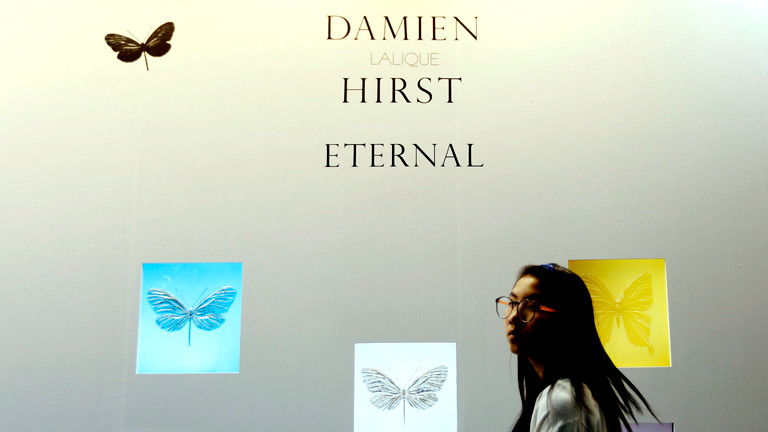 Eine Besucherin geht an den Schmetterlingen von Damien Hirst vorbei