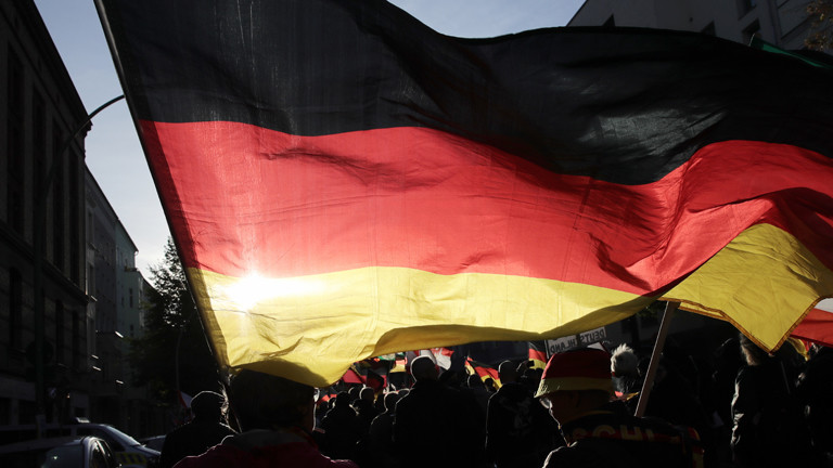 Teilnehmer der rechtspopulistischen Demonstration «Tag der Nation» des Bündnisses «Wir für Deutschland» ziehen mit einer Deutschlandfahne durch die Stadt.