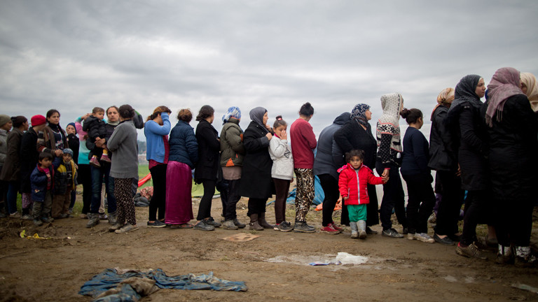 Flüchtlinge stehen am 12.03.2016 im Flüchtlingslager in Idomeni an der Grenze zwischen Griechenland und Mazedonien im Schlamm für eine Kleiderspende an