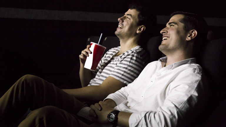 Zwei Männer im Kino - sie lachen.