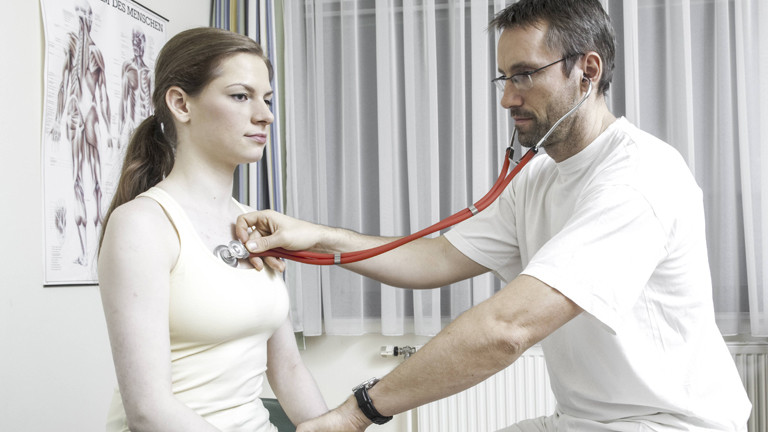 Arzt hört den Herzschlag einer Patientin ab