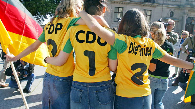 Frauen mit Trikots, auf denen "FDP", "CDU" und "Die Grünen" steht.