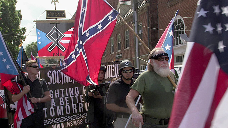 Demonstranten mit USA-Fahnen und rechten Symbolen
