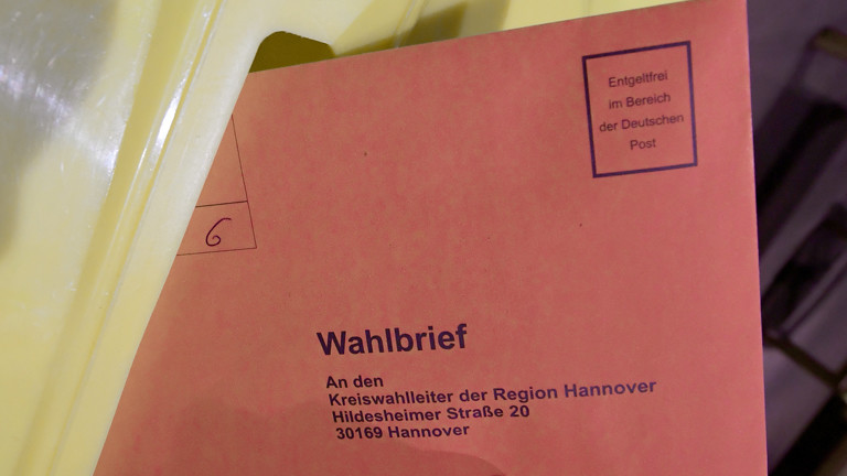 Wahlbrief beim Einwurf in die Urne