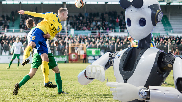 Ein Roboter beobachtet ein Amateurfußballspiel.