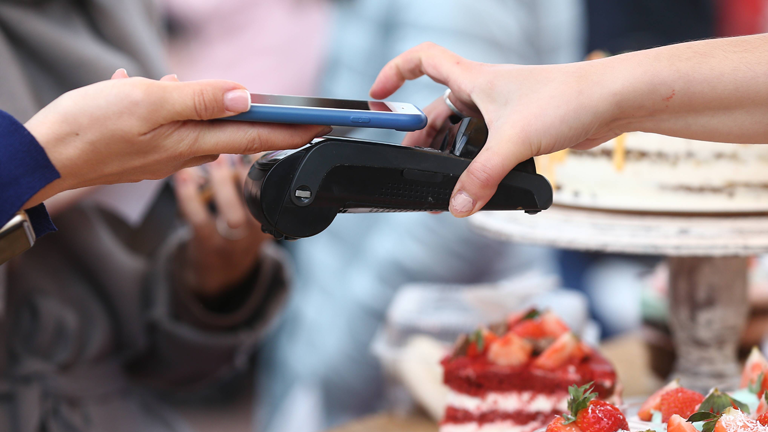 Ein Smartphone wird über ein Kartenlesegerät gehalten