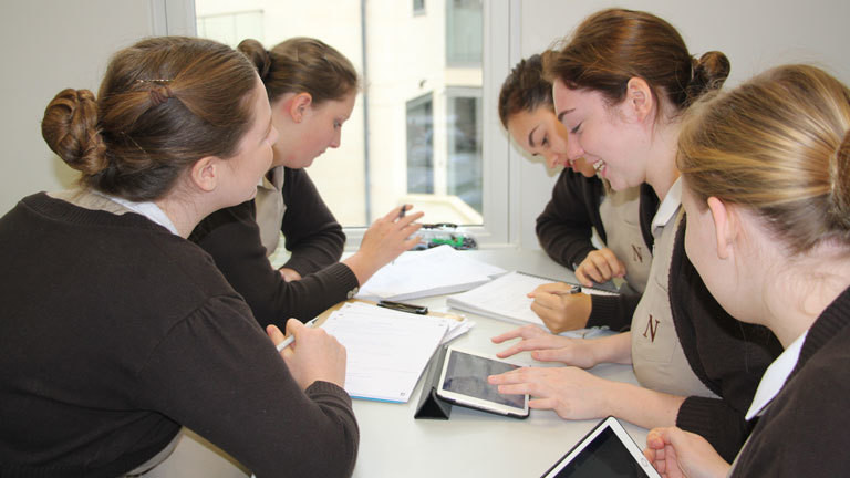 Auszubildende am Norland College sitzen an einem Tisch und lernen.