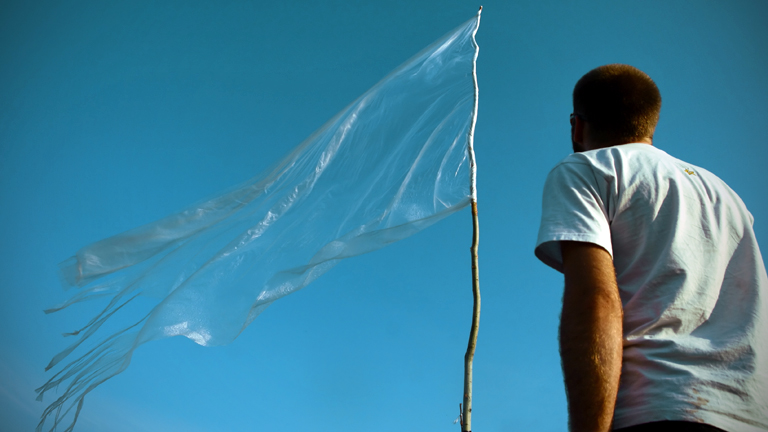 Ein Mann schaut auf eine weiße Fahne.