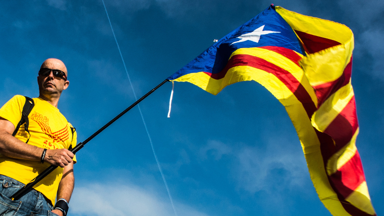 Ein Demonstrant in Spanien schwingt die katalonische Flagge.
