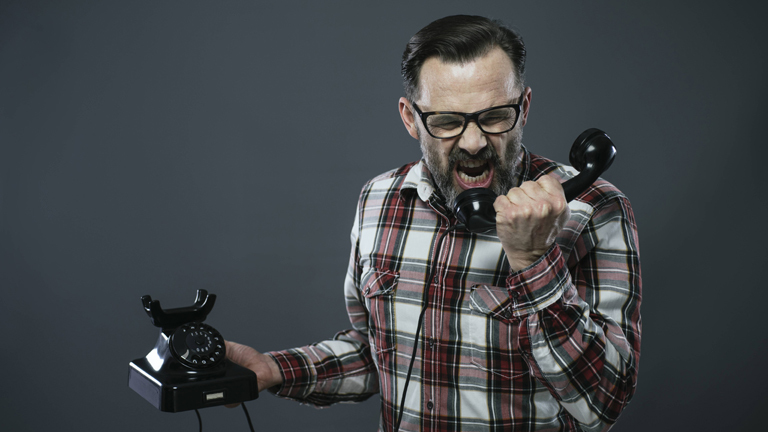 Mann brüllt ins Telefon.