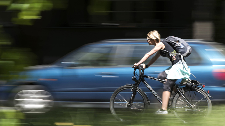 Fahrradfahrerin neben Auto