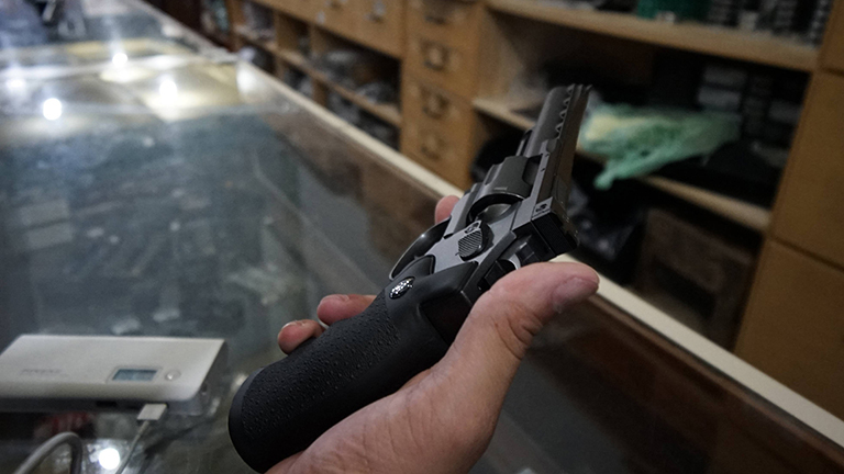 In einem Waffengeschäft in Brasilien hält jemand eine Kleinwaffe in der Hand; es sind Hand und Waffe zu sehen sowie der Laden (21.01.2019)