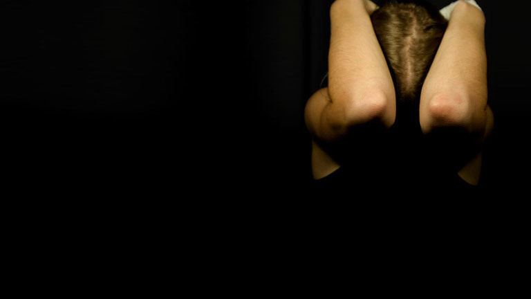 Eine Frau verschränkt ihre Arme über ihrem Kopf