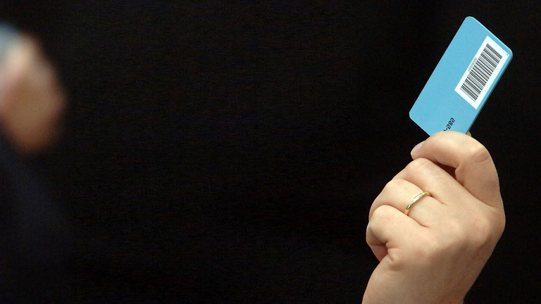 Ein Bundestagsabgeordneter hält seine Stimmkarte hoch