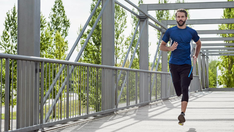 Ein Mann joggt über eine Brücke