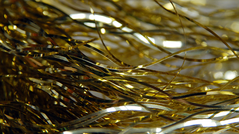 Goldenes Lametta liegt auf weißem Hintergrund