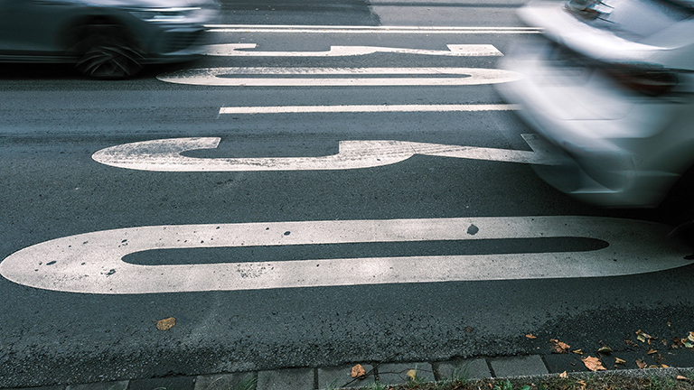 In der Düsseldorfer Innenstadt fahren zwei Autos nebeneinander; auf beiden Fahrbahnen ist 30 markiert (16.09.2022)