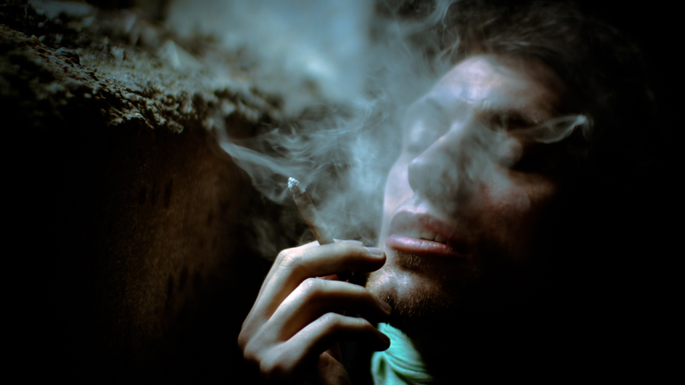 Ein Mann raucht einen Joint.