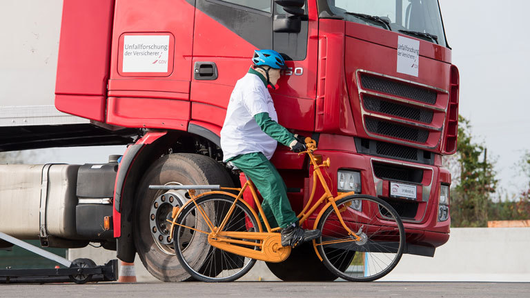 Ein Dummy-Radfahrer crasht gegen einen LKW