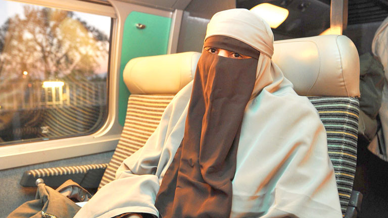 Eine Frau trägt in einem französischen Zug einen Nikab.