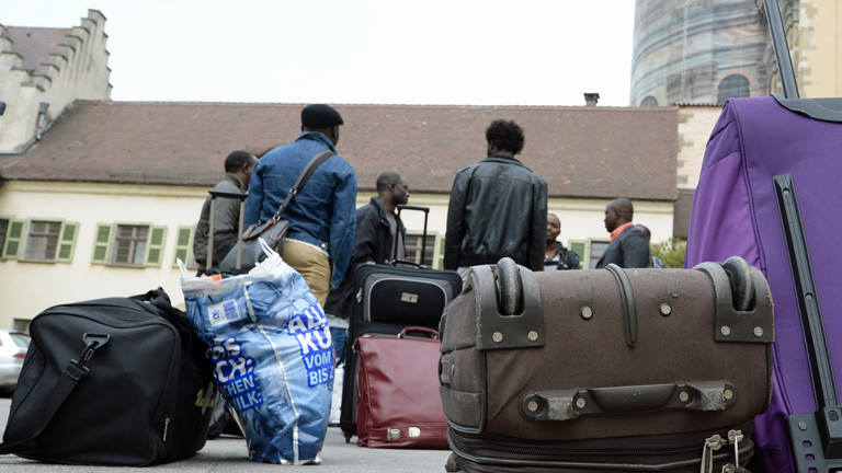Mehrere Flüchtlinge stehen am 03.04.2014 in Weingarten (Baden-Württemberg) nach ihrer Ankunft vor dem Gästehaus des Klosters Weingarten.