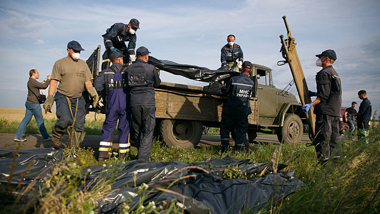 Hilfskräfte befördern an der Absturzstelle von Flug MH17 Leichensäcke auf einen LKW.