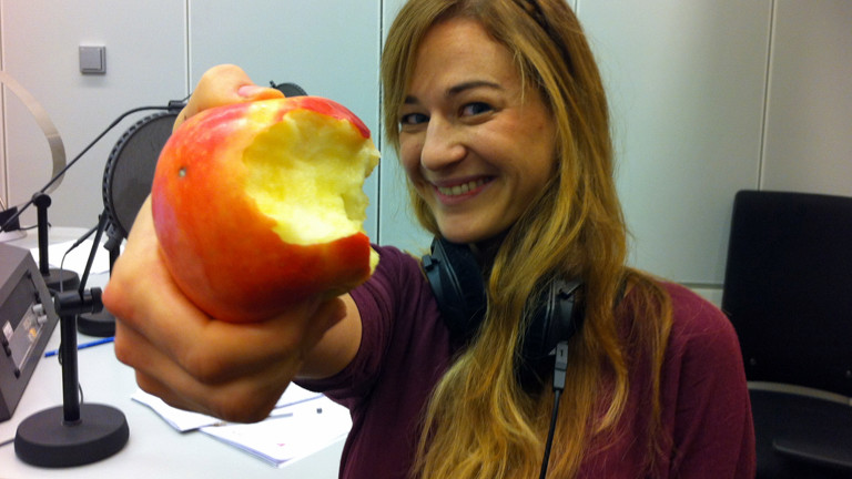 Anna Kohn präsentiert ihren angebissenen Apfel im DRadio-Wissen-Studio.