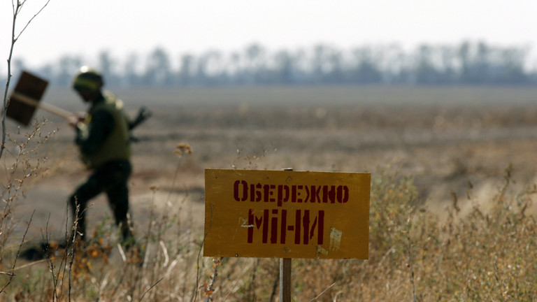Ein ukrainischer Soldat markiert am 06.09.2014 ein Gelände in der Nähe von Mariupol mit dem Schild "Achtung Minen".