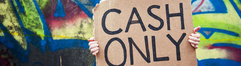 Ein Mann hält ein Pappschild in der Hand: Cash Only.