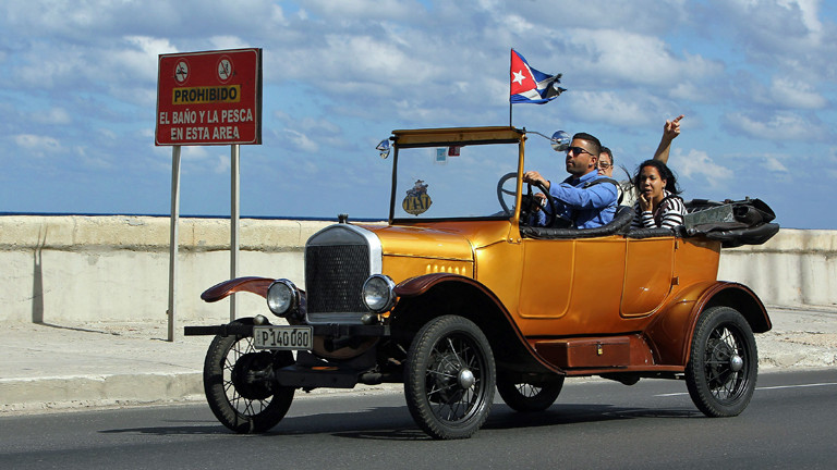 Am 17.12.2014 fahren ein paar Leute in einem Oldtimer durch Havana in Kuba.