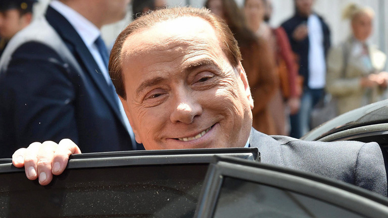 Silvio Berlusconi steigt in ein Auto ein und grinst in die Kamera (20. Mai 2014); Bild: dpa