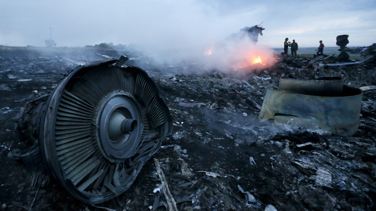 An der Absturzstelle der MH17 liegen Flugzeugteile, es qualmt und kleine Feuer brennen; Bild: dpa