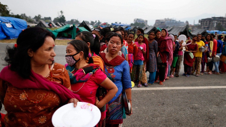 Frauen stehen in einer langen Schlange für Lebensmittel an. Viele halten Teller in der Hand. 8. Mai 2015 nach dem Erdbeben in Nepal; Bild: dpa