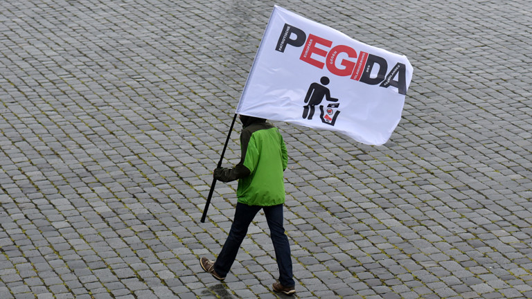 Ein Pegida-Demonstrant mit Fahne läuft am 01.06.2015 durch Dresden.