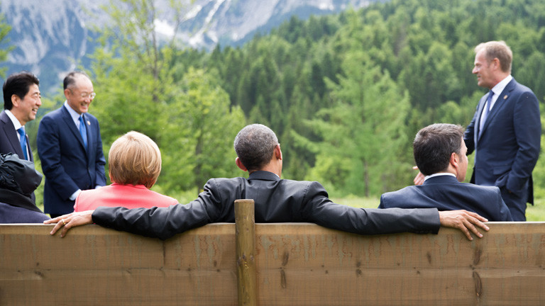 Auf einer Bank sitzen US-Präsident Barack Obama (Mitte), Angela Merkel (links) und Italiens Ministerpräsident Matteo Renzi (rechts). Das Bild zeigt die drei von hinten, am 08.06.2015 beim G7-Gipfel; Bild: dpa