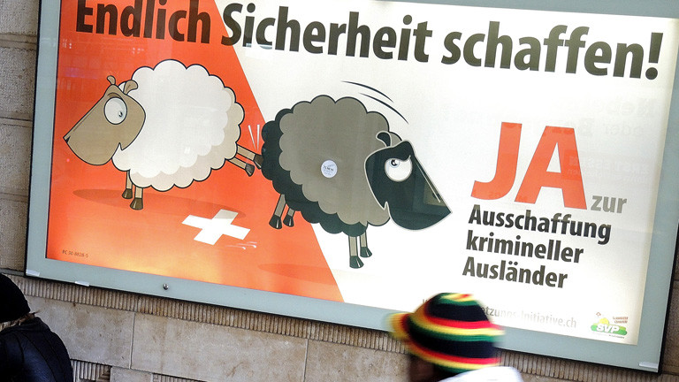 Ein Mann geht an einem Plakat der Schweizerischen Volkspartei vorbei, auf dem die "Ausschaffung" (Ausweisung) krimineller Ausländer gefordert wird; Foto: dpa