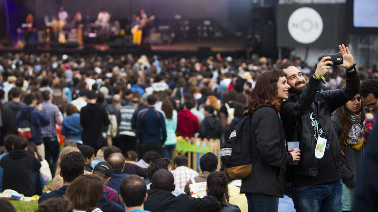 Während des Festivals Primavera Sound steht ein Paar im Publikum und macht ein Selfie von sich.