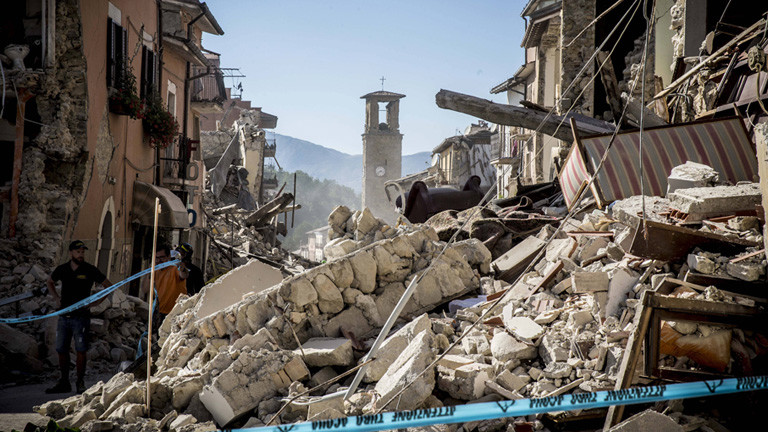Nach dem schweren Erdbeben (24.08.16) sind Häuser entlang einer schmalen Straße in dem Ort Amatrice zerstört. Am Ende der Straße steht noch ein Kirchturm.