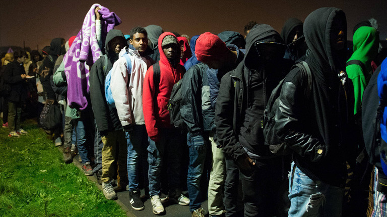 Flüchtlinge stehen in einer langen Schlange.