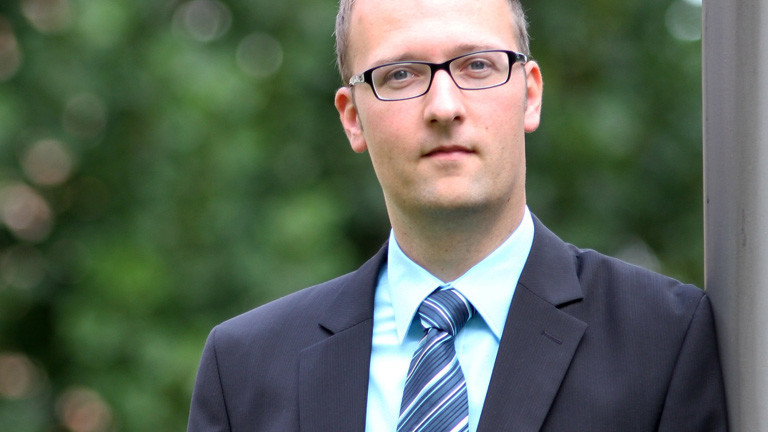 Florian Endres (19.09.2014) von der Beratungsstelle Radikalisierung des BAMF. Er hat kurze Haare. Er trägt Brille, Anzug und Schlips; Foto: dpa, Robert Ullinger/BAMF