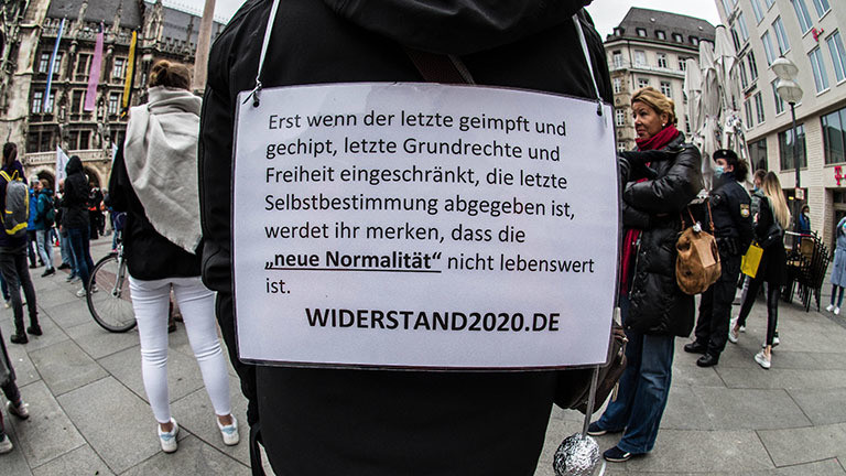 Bei einem Protest in München trägt jemand ein Schild mit sich, darauf ist ein Hinweis auf Widerstand2020 (02.05.2020)