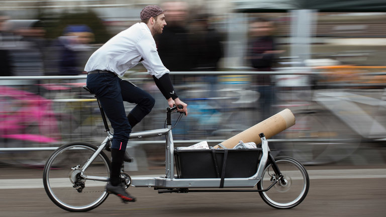 Ein Fahrradfahrer transportiert Lasten mit einem Lastenfahrrad