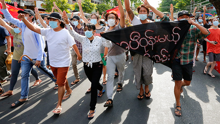In Rangun, Myanmars Haupstadt, laufen bei einem Flashmob gegen das Militär viele junge Menschen auf einer Straße. Sie recken die Arme in die Luft (06.05.2021)
