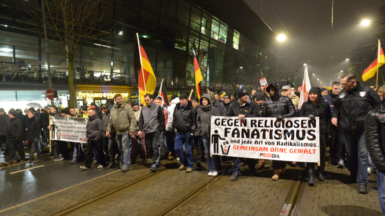 Teilnehmer der islamkritischen Pegida-Bewegung ziehen am 05.01.2015 mit Transparenten und Fahnen bei einer Kundgebung in Dresden (Sachsen) am Stadion des Fußball-Drittligisten Dynamo Dresden vorbei.