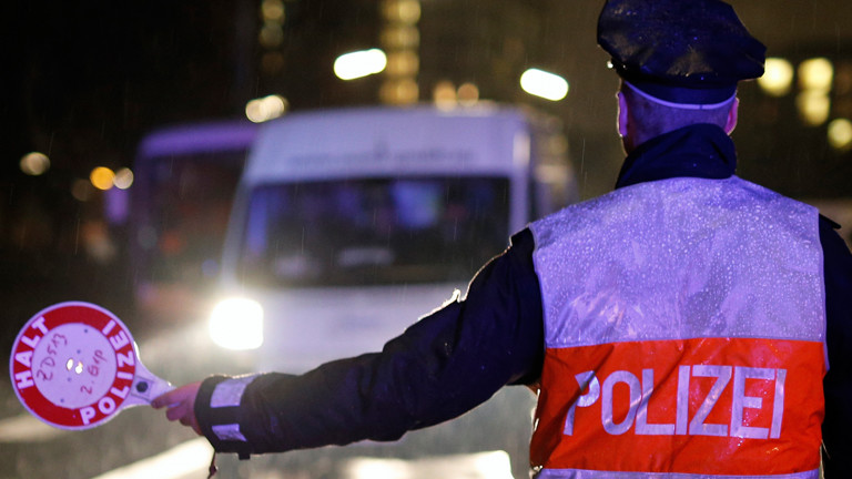 Ein Polizeibeamter hält am 20.02.2015 in Hamburg ein Fahrzeug zu einer Verkehrskontrolle an.