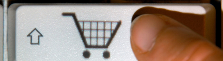 Finger tippt auf der Tastatur auf Einkaufswagen-Symbol