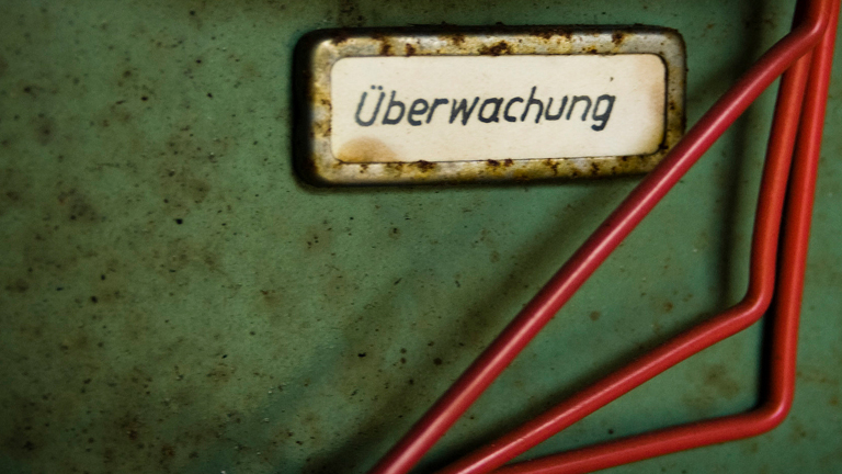 Auf einem Schild an einem Rollcontainer steht Überwachung