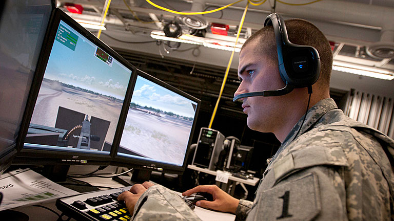 Soldat der US Army sitzt mit Kopfhörern an einem Computer